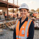 A professional portrait of a diverse female project manager smiling on a construction site.